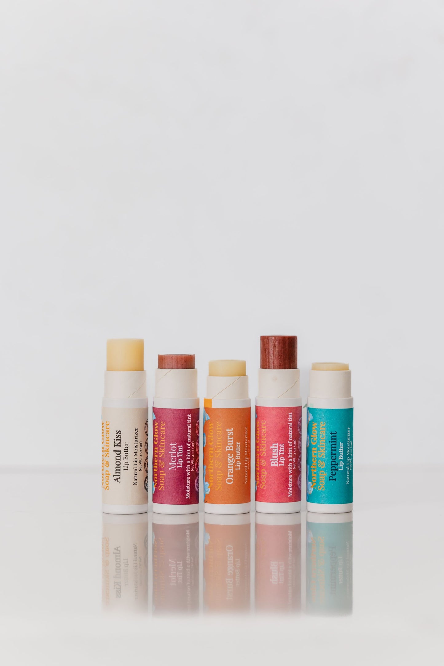 Set of six lip balms with visible brand names on a light gray background