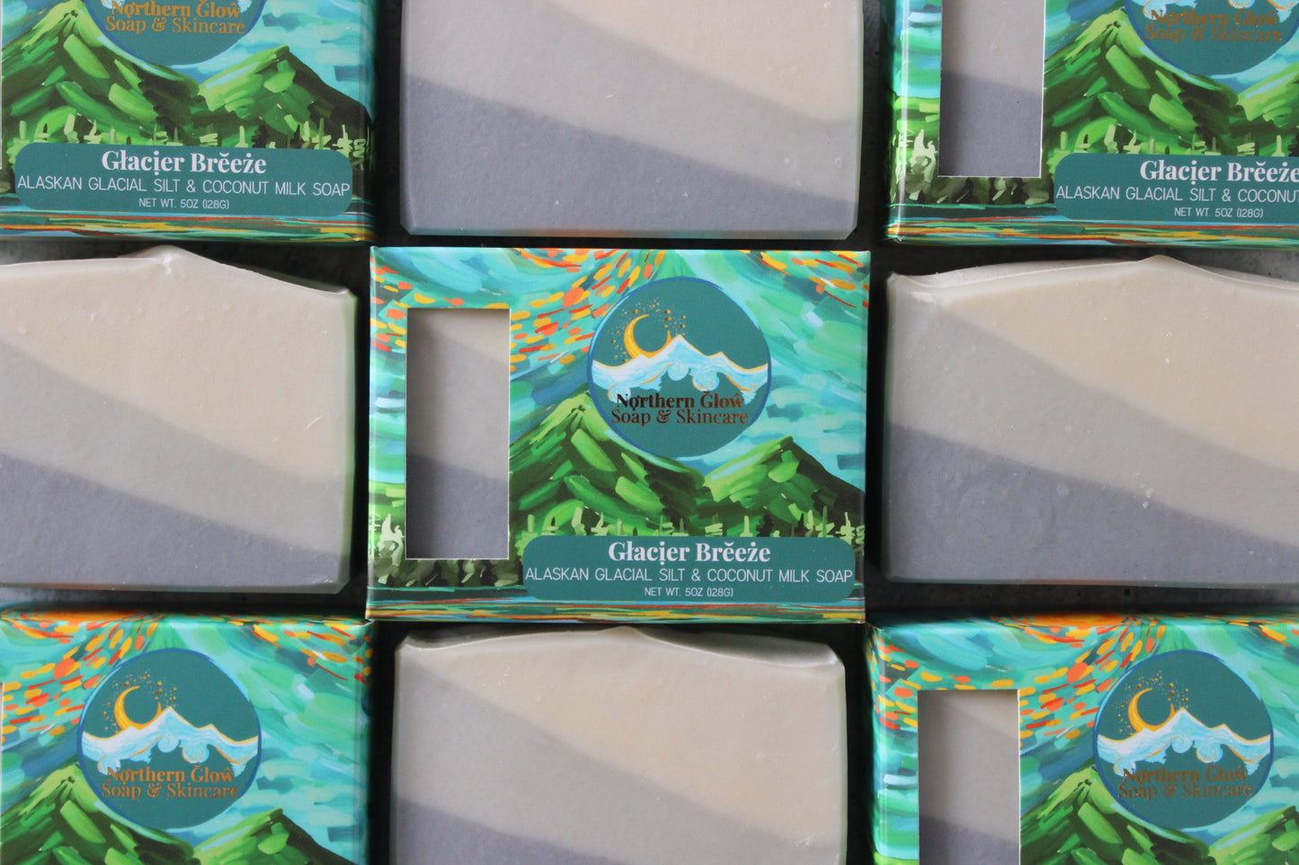 Multiple boxes of Northern Glow Glacier Breeze soap with green mountain and blue sky design.
