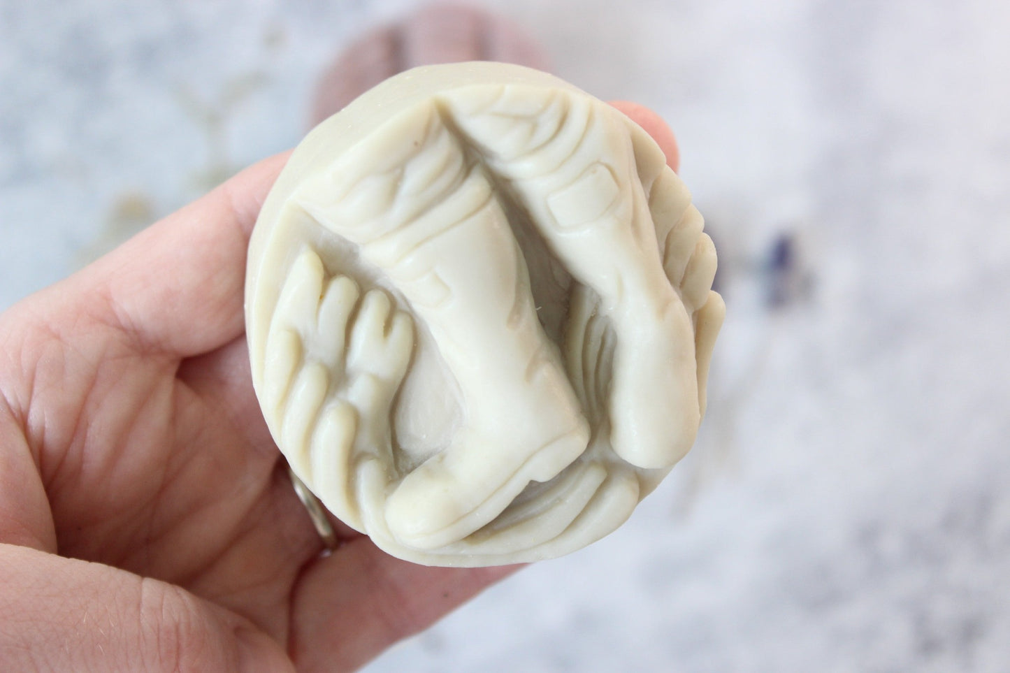 Alaskan Seaside Soaps, shaped as boots. Soap is held in a hand.