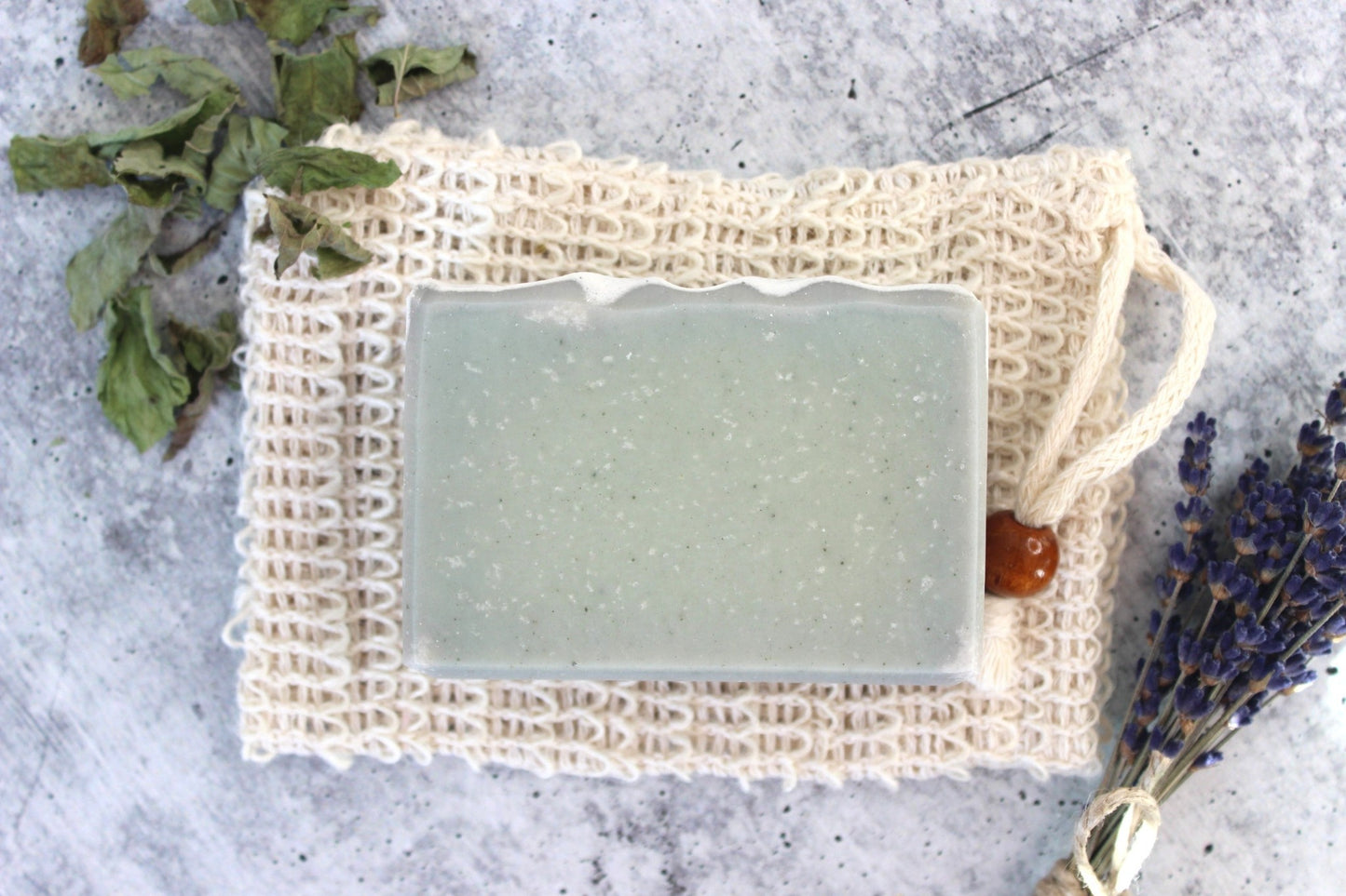Goat Milk Soap with Green Clay soap on a cambric soap saver. Dried florals in the background.
