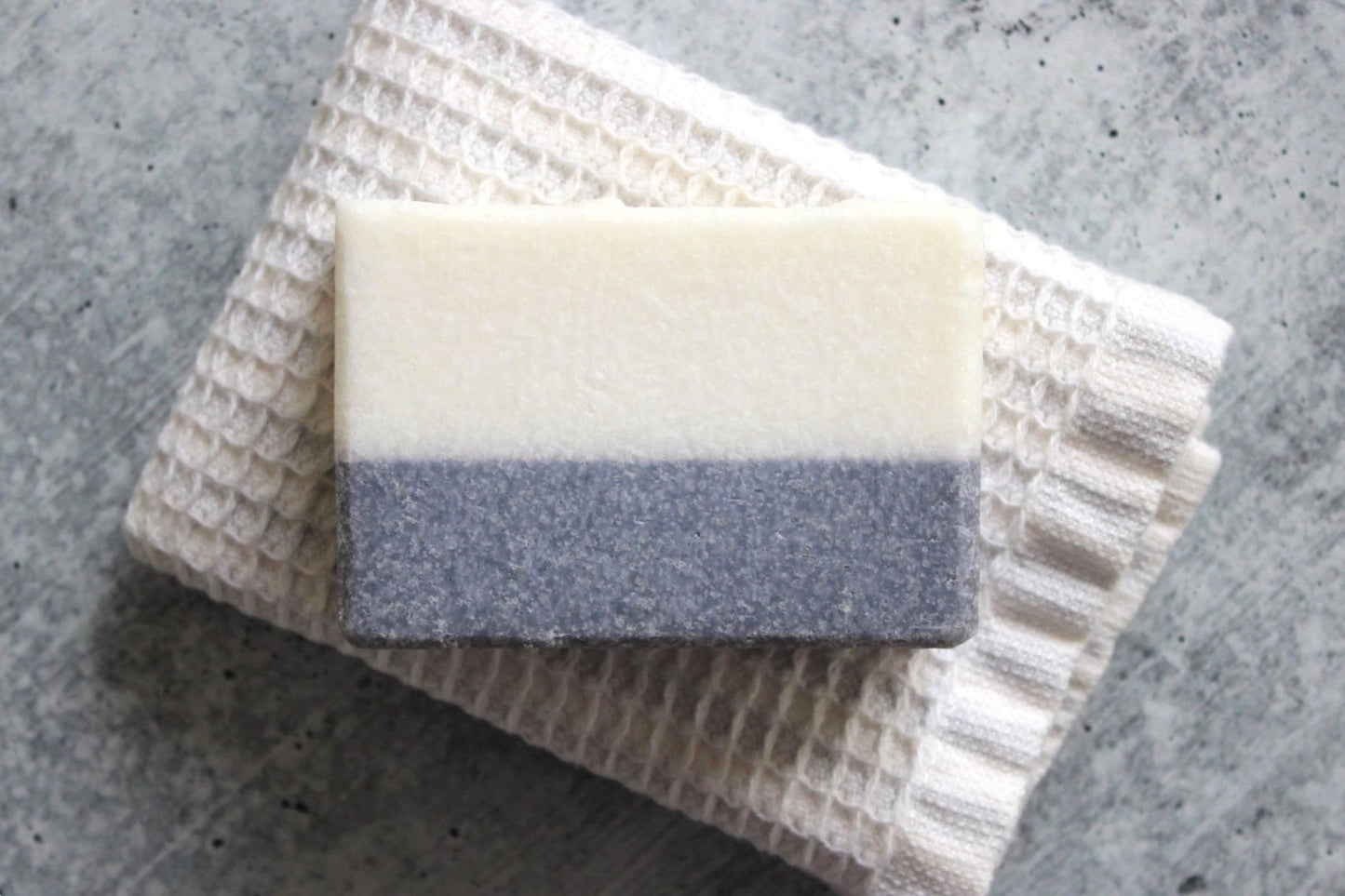 Bar of soap with textured view of the sea salt in shades of blue and white. 