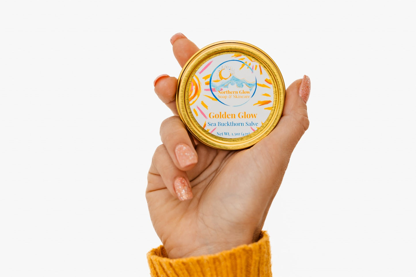 Apricot Oil and Beeswax Salves in Golden Glow in a woman's hand.