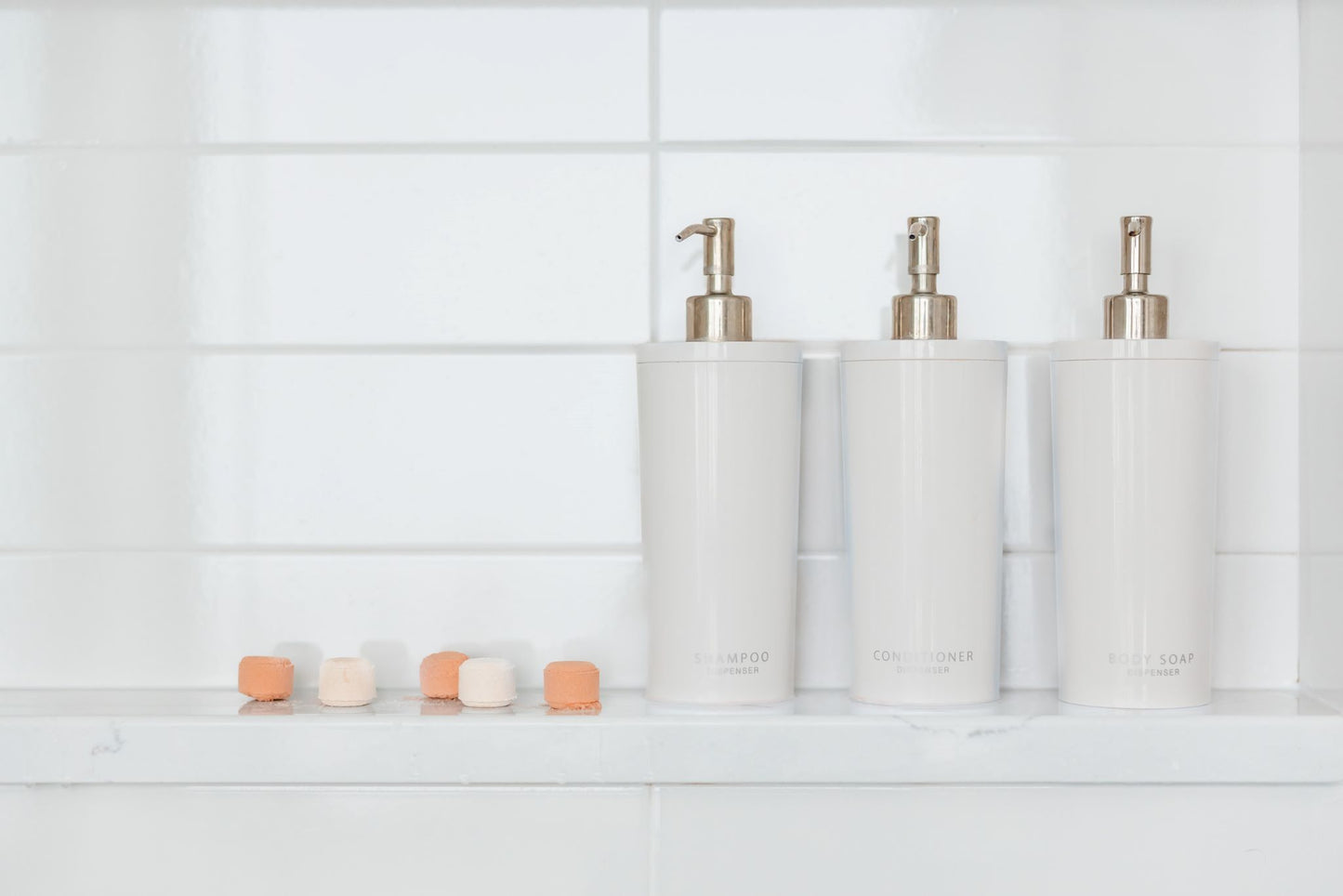 Aromatherapy shower steamers sitting on a shower shelf. 