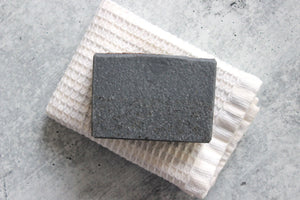 Charcoal coffee soap on a white washcloth.