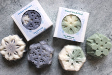 Load image into Gallery viewer, Coconut Oil and Sea Salt Snowflake Soaps pictured in Alaskan Saltwater scent and Winter Wonderland scent.
