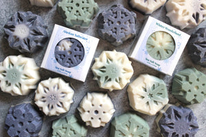 Coconut Oil and Sea Salt Snowflake Soaps in and out of white boxes.