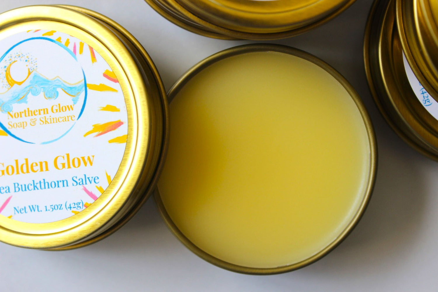 Open tin of Golden Glow salve with Northern Glow branding on a white background
