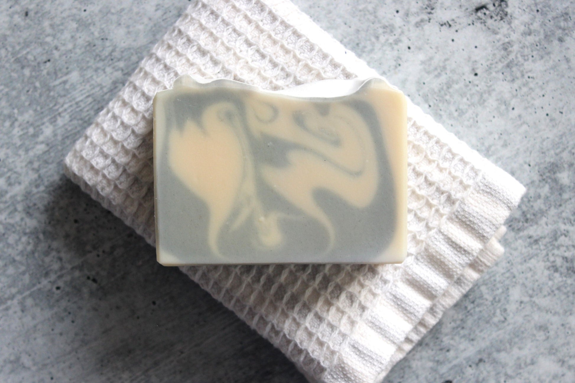 Lavender and Sage goat milk soap on a white textured towel.