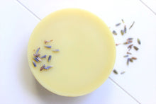 Load image into Gallery viewer, Mango butter lotion bar with dried lavender spread around.
