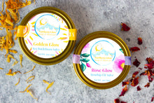 Load image into Gallery viewer, Natural salves by Northern Glow Soap and Skincare.  Golden Glow and Rose Glow are in golden tins.
