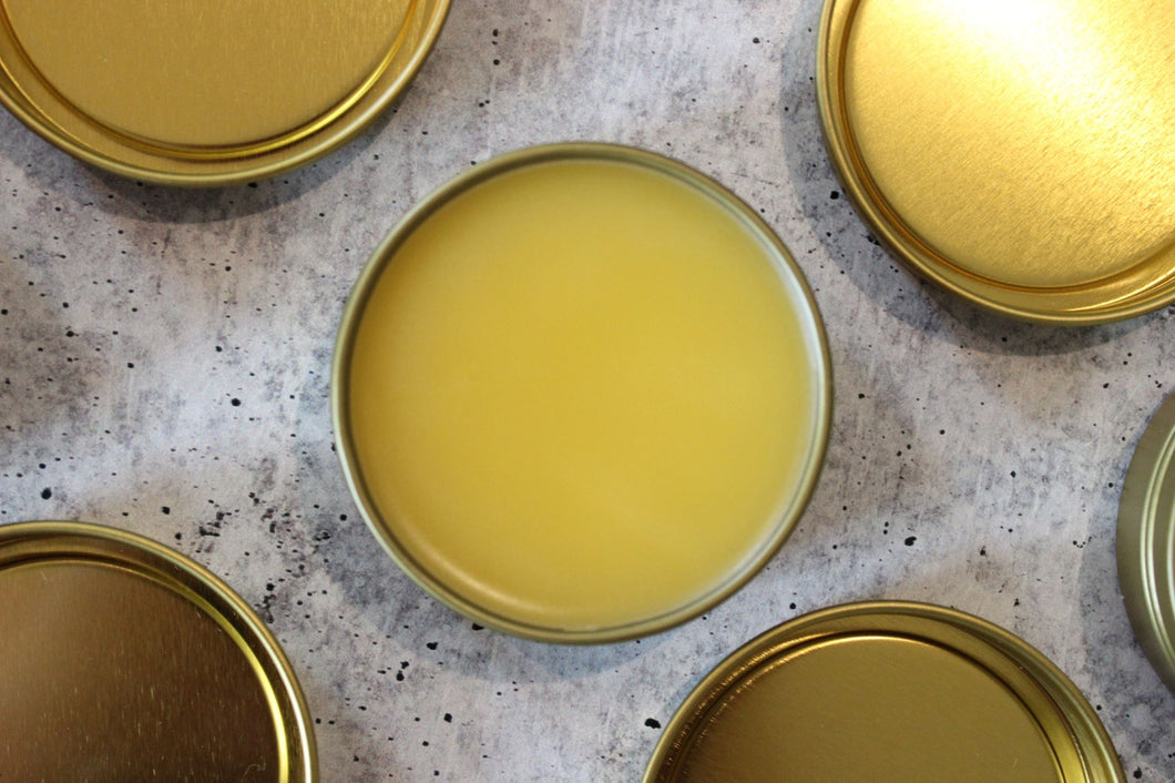 Natural salves with beeswax and seabuckthorn fruit oil in a golden tin.
