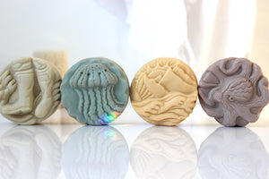Alaskan Seaside Soaps shaped as boots, jellyfish, mountains and an octopus in various colors.