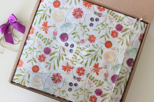 Gardening Gift Box for Mother's Day, with floral tissue paper and a purple bow.