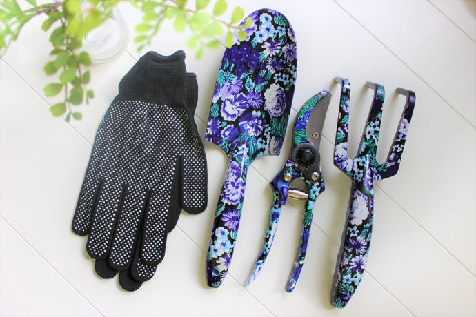 Purple floral handheld gardening tools with black gardening gloves.