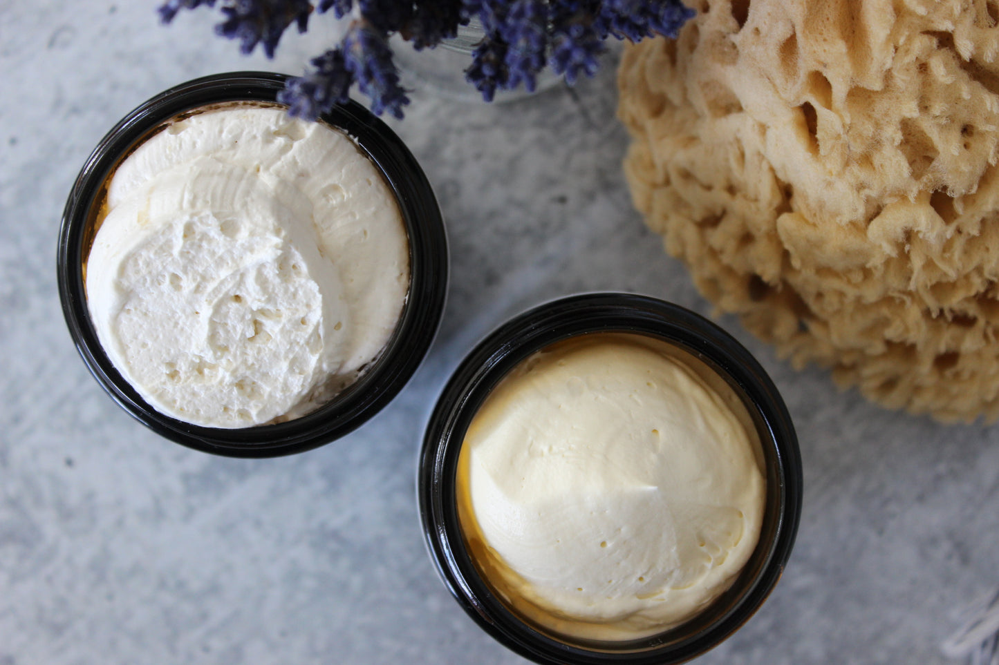 Natural Whipped Body Butter next to sponge and lavender flowers.